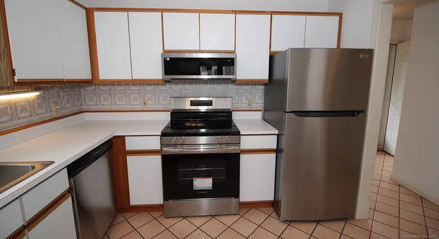 a kitchen with a refrigerator a stove a microwave and cabinets