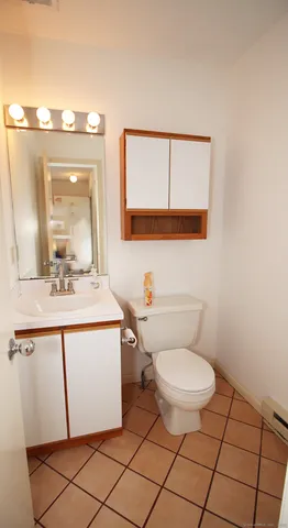 a bathroom with a toilet a sink and mirror