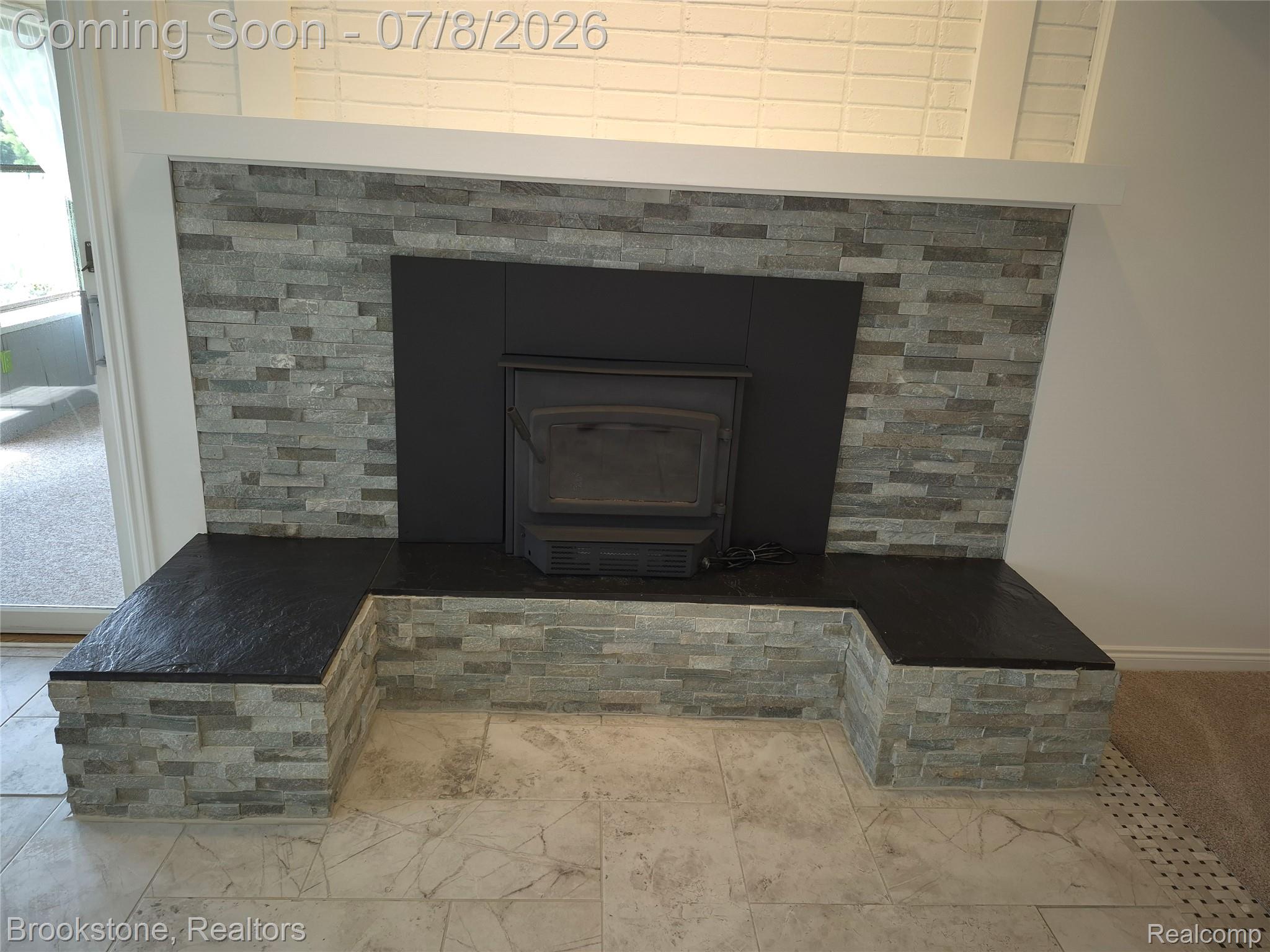 4140 South Henderson Road Davison, MI 48423 - Photo 32 of 98 Stone veneer fireplace with an integrated wood-burning insert