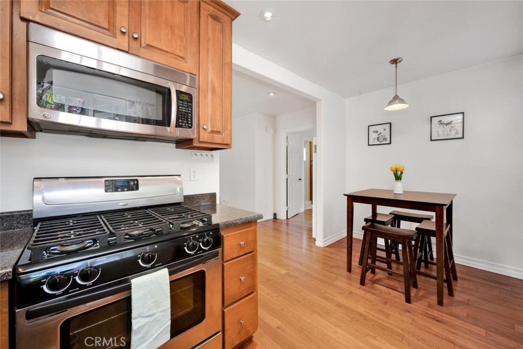 a kitchen with stainless steel appliances a stove a microwave and wooden floors