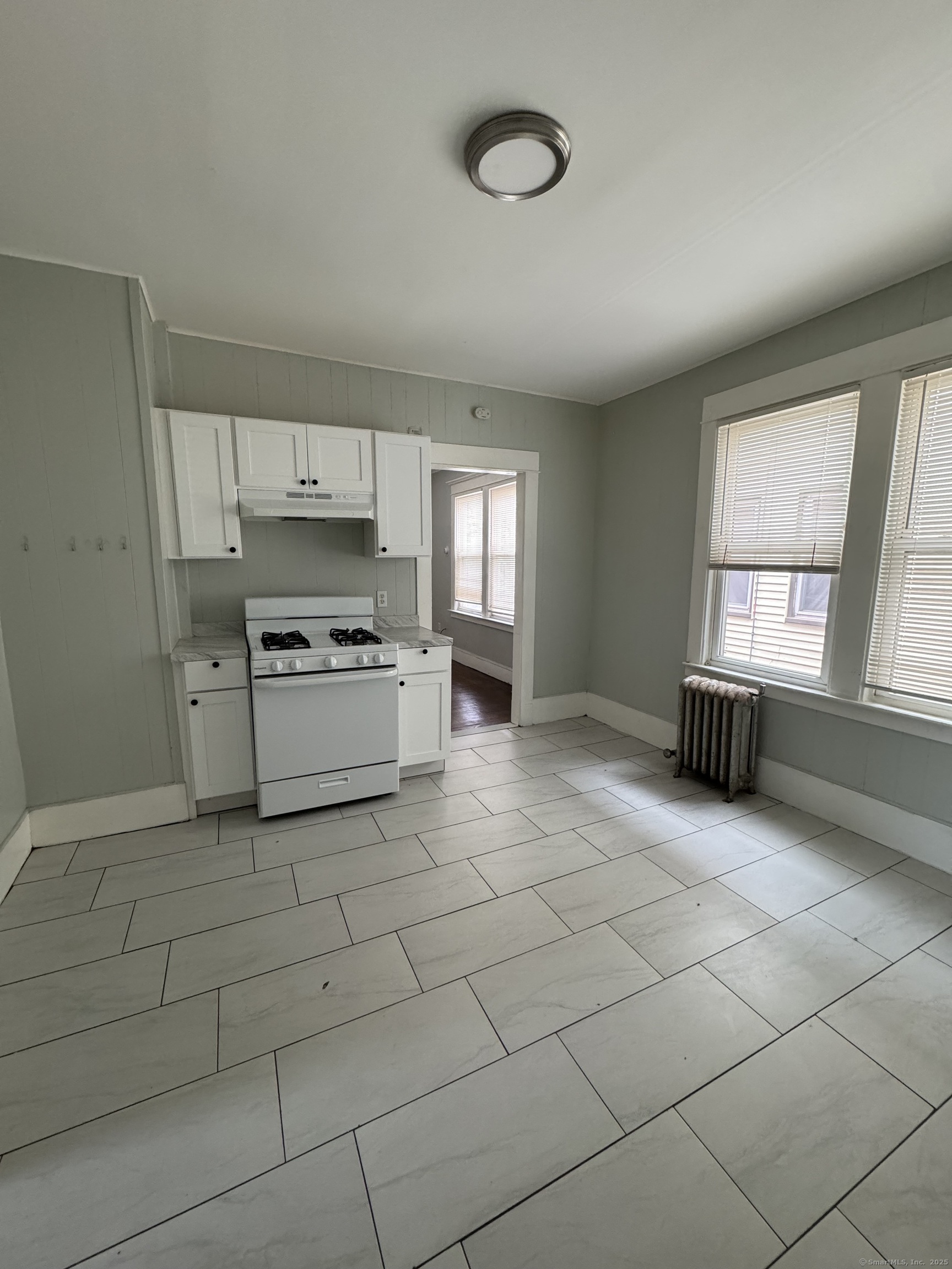 a kitchen with granite countertop a stove a sink and a refrigerator