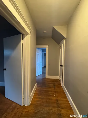 a view of a hallway with wooden floor and closet