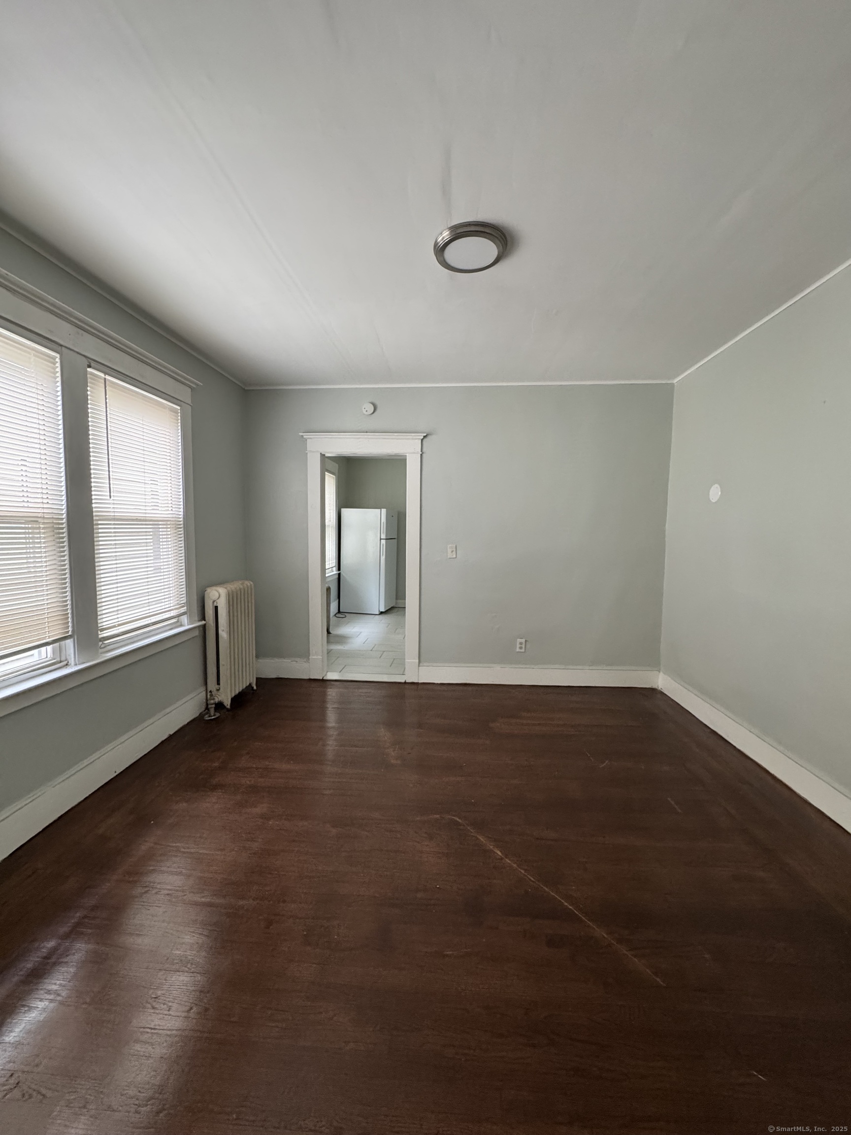 916 Winchester Avenue, Unit 1 New Haven, CT 06511 - Photo 6 of 10 an empty room with wooden floor and windows