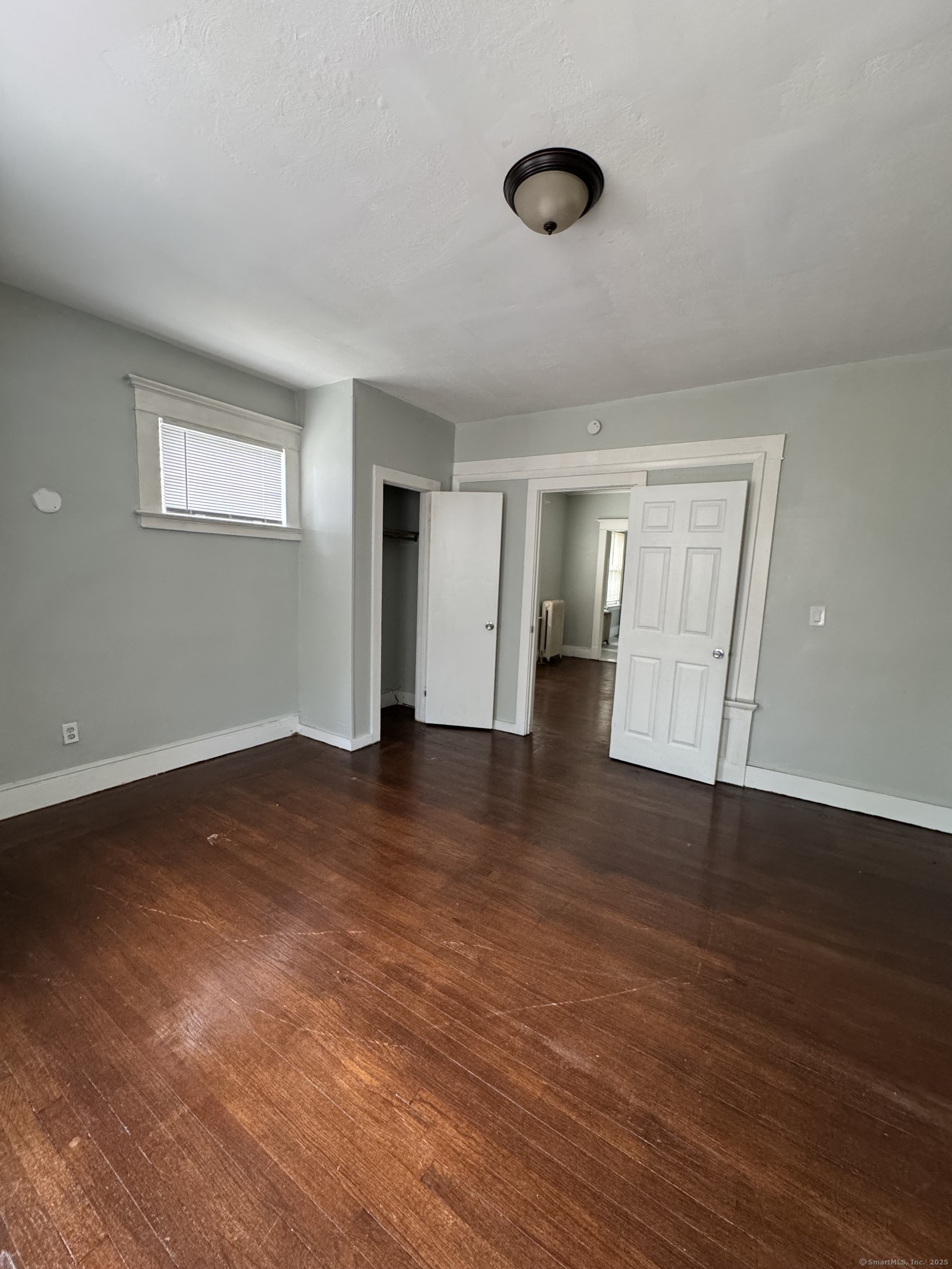 916 Winchester Avenue, Unit 1 New Haven, CT 06511 - Photo 7 of 10 a view of an empty room with wooden floor and a window