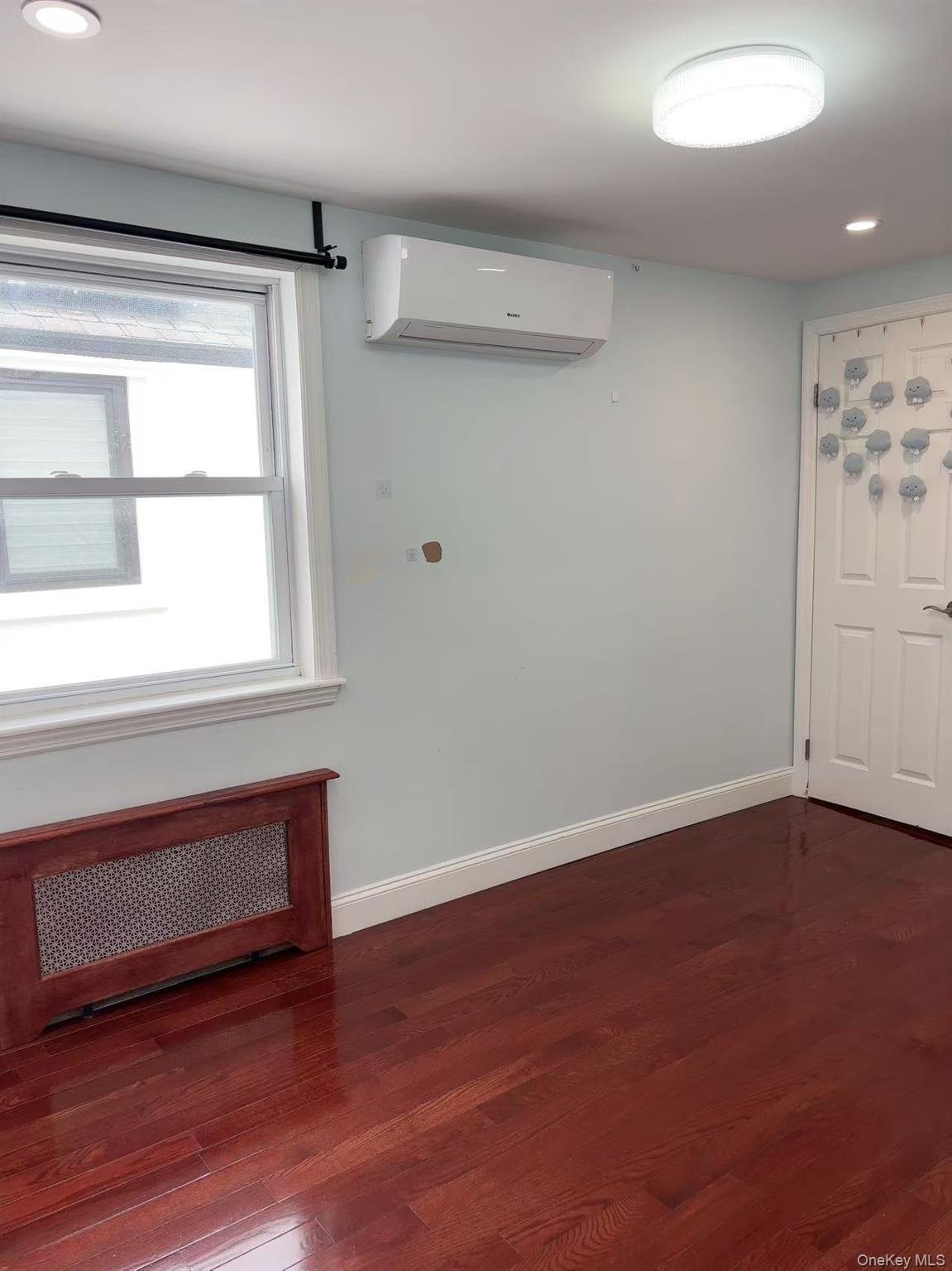 75-47 193rd Street Queens, NY 11366 - Photo 12 of 27 a view of an empty room with wooden floor and a window