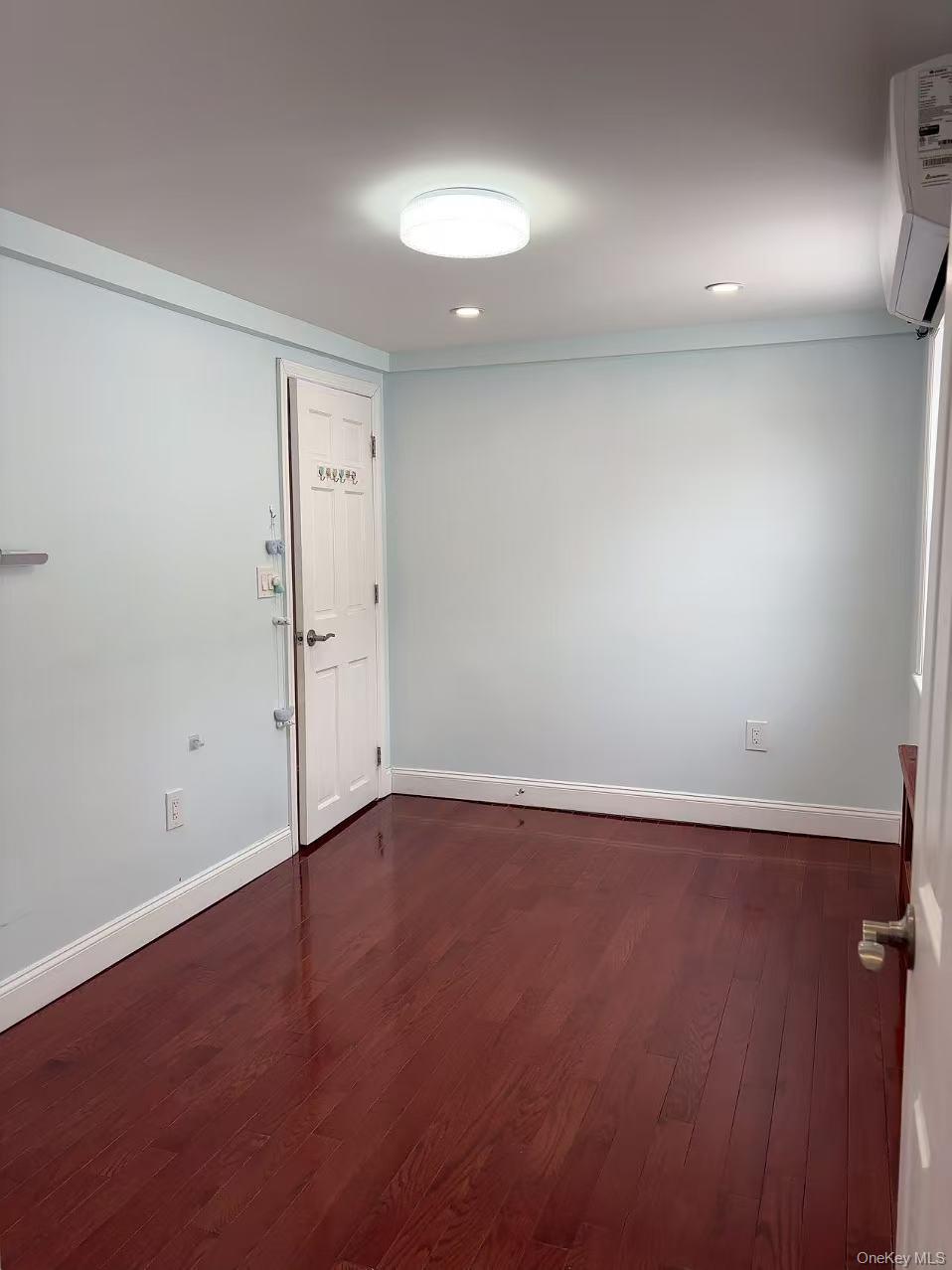 75-47 193rd Street Queens, NY 11366 - Photo 13 of 27 an empty room with wooden floor and windows
