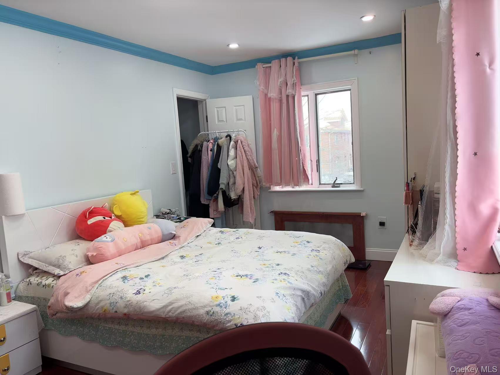 75-47 193rd Street Queens, NY 11366 - Photo 15 of 27 a bedroom with a bed and a window