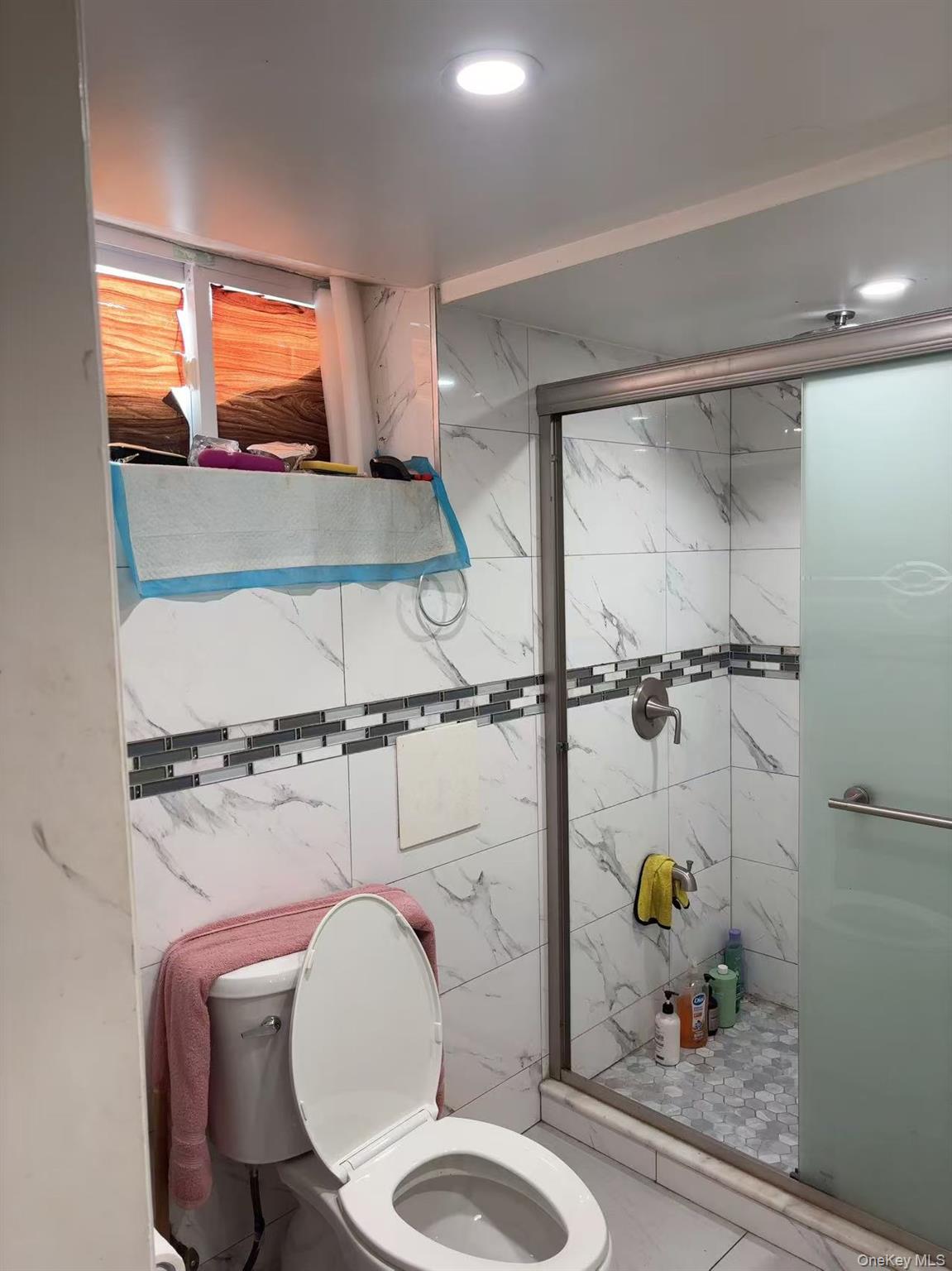 75-47 193rd Street Queens, NY 11366 - Photo 22 of 27 a bathroom with a toilet mirror vanity and window