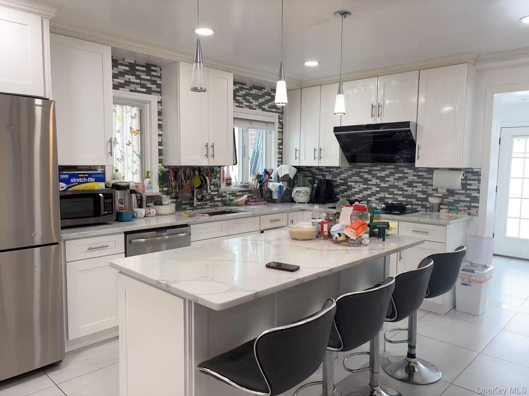 75-47 193rd Street Queens, NY 11366 - Photo 6 of 27 a kitchen with stainless steel appliances a stove a sink a microwave a refrigerator and cabinets