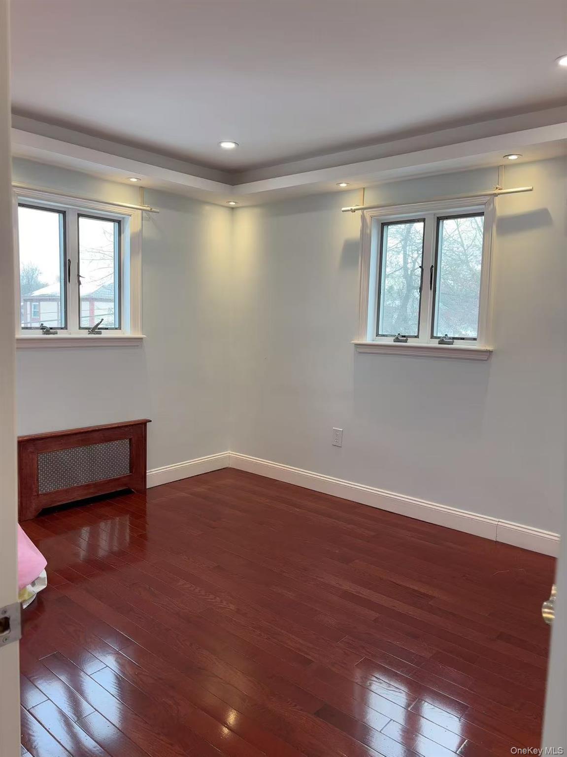 75-47 193rd Street Queens, NY 11366 - Photo 9 of 27 a view of an empty room with wooden floor and a window