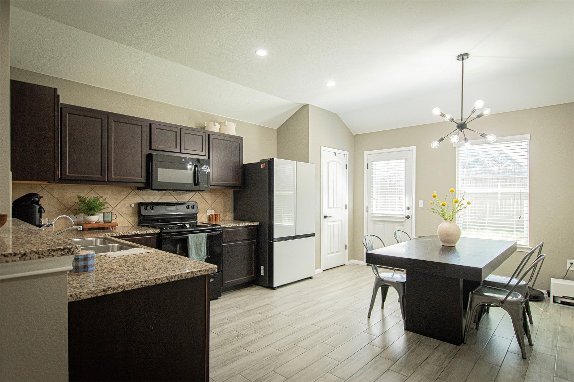 3513 Ortman Drive Pflugerville, TX 78660 - Photo 6 of 17 a kitchen with a refrigerator a stove a sink dishwasher a dining table and chairs with wooden floor
