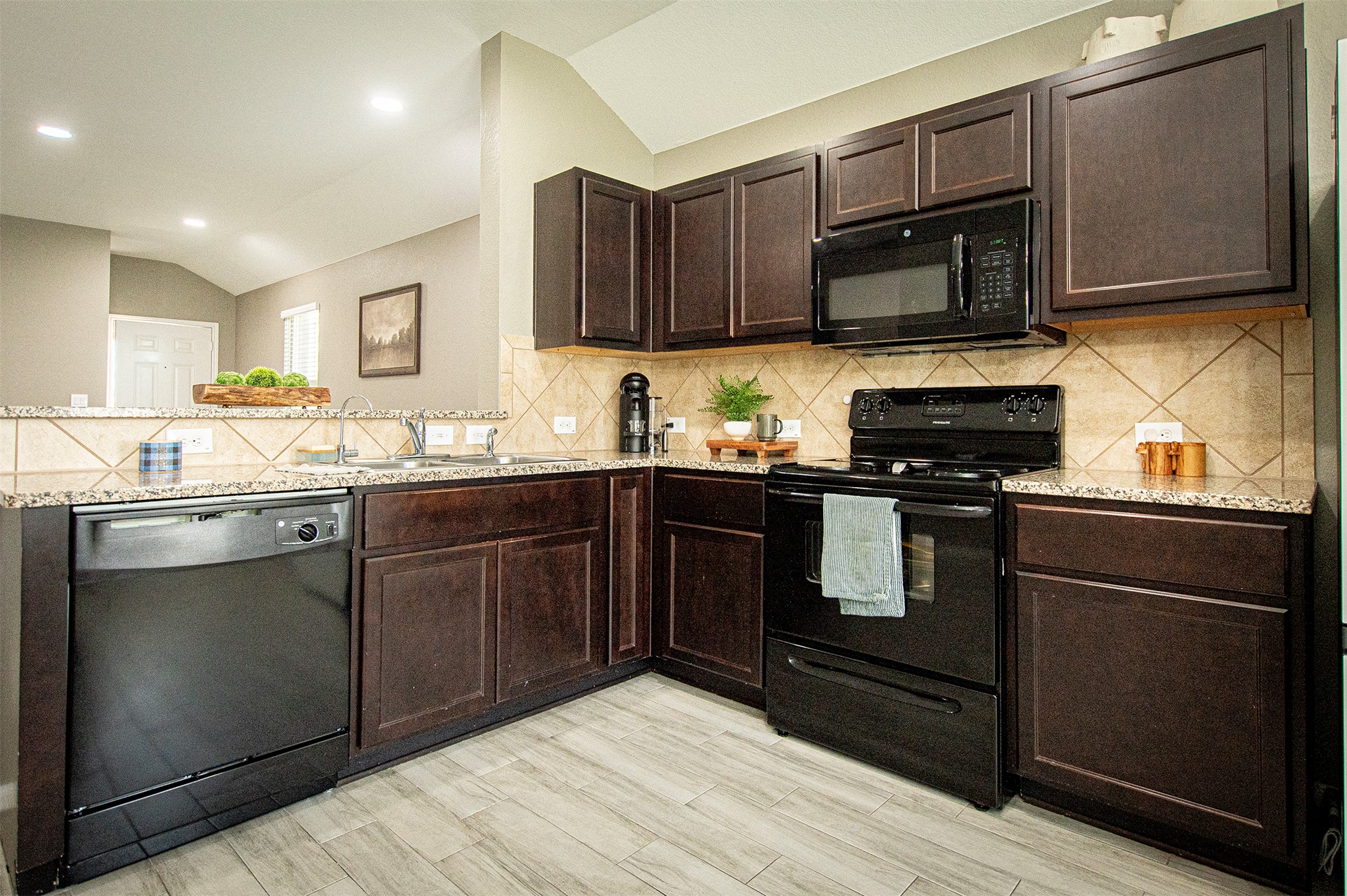 3513 Ortman Drive Pflugerville, TX 78660 - Photo 7 of 17 a kitchen with stainless steel appliances granite countertop a stove a sink dishwasher and a microwave