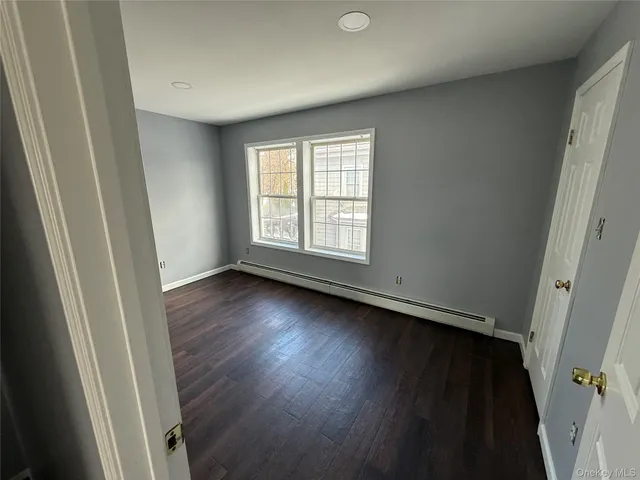 an empty room with wooden floor and window