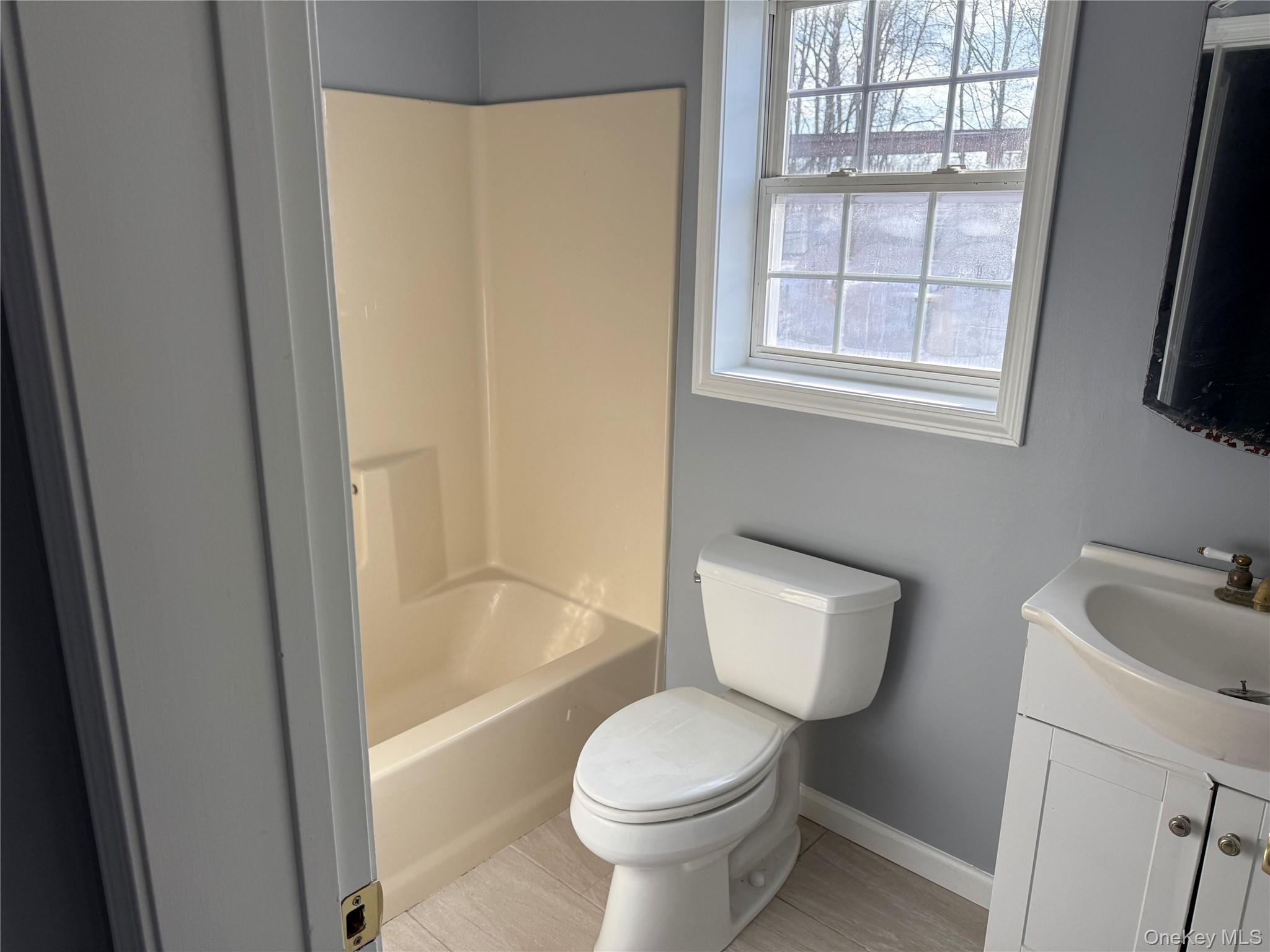 17 Orchard Place, Unit C Poughkeepsie, NY 12601 - Photo 14 of 20 a white toilet sitting next to a bathroom sink