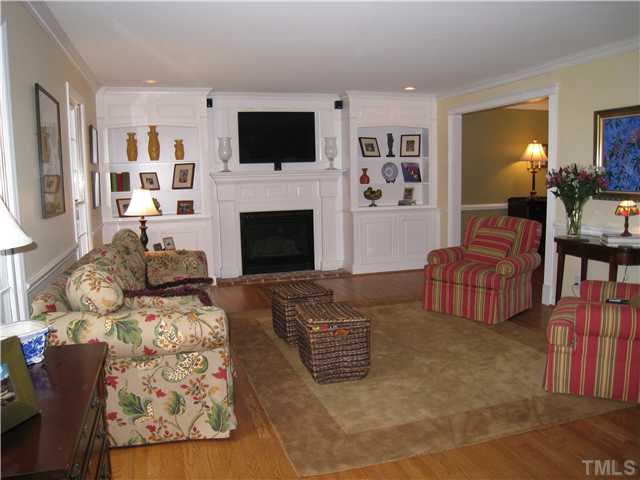5709 Edgedale Drive Raleigh, NC 27612 - Photo 3 of 12 a living room with furniture a flat screen tv and a fireplace