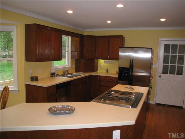 5709 Edgedale Drive Raleigh, NC 27612 - Photo 6 of 12 a kitchen with stainless steel appliances granite countertop a sink a stove and a refrigerator