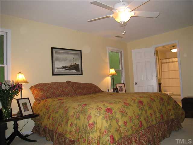 5709 Edgedale Drive Raleigh, NC 27612 - Photo 8 of 12 a bedroom with a bed and a chandelier