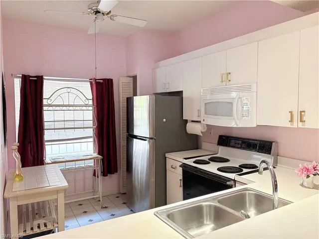 a kitchen with a refrigerator a stove a sink and a cabinets