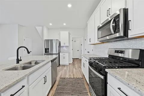 a kitchen with stainless steel appliances a sink stove and cabinets