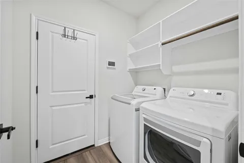 a view of washer and dryer with bathroom in the background