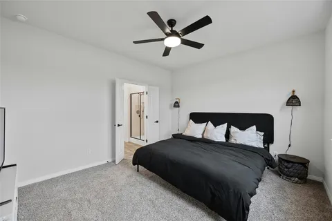 a bedroom with a bed and a ceiling fan