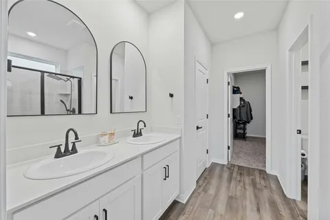 a spacious bathroom with a double vanity sink and mirror