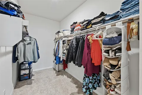 a view of walk in closet with clothes and shoes