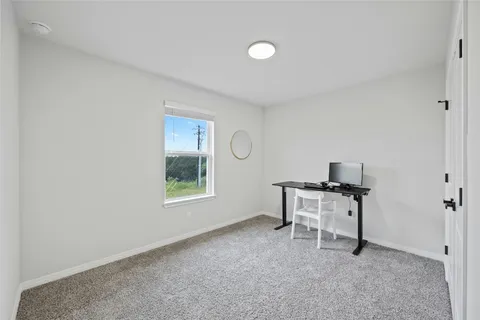 a view of a workspace with furniture and a window