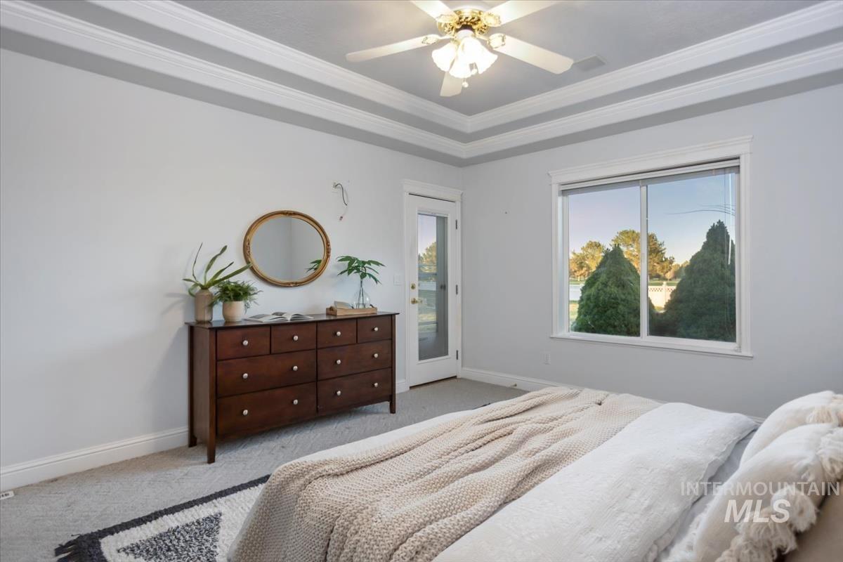 25074 The Driving Lane Caldwell, ID 83607 - Photo 12 of 29 Carpeted bedroom featuring crown molding, access to outside, ceiling fan, and a tray ceiling
