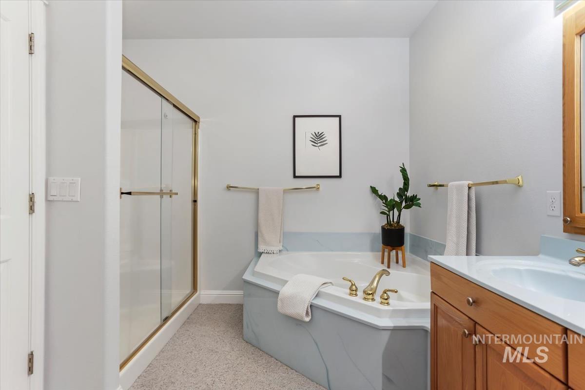 25074 The Driving Lane Caldwell, ID 83607 - Photo 15 of 29 Full bathroom featuring vanity, a shower stall, and a garden tub