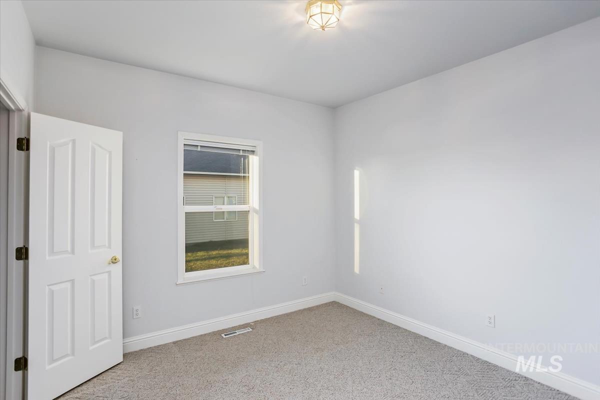 25074 The Driving Lane Caldwell, ID 83607 - Photo 17 of 29 Unfurnished room featuring light colored carpet and baseboards