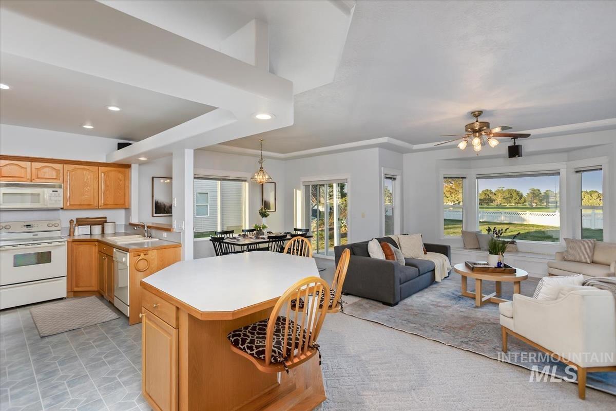 25074 The Driving Lane Caldwell, ID 83607 - Photo 29 of 29 Kitchen with light countertops, white appliances, open floor plan, a center island, and hanging light fixtures