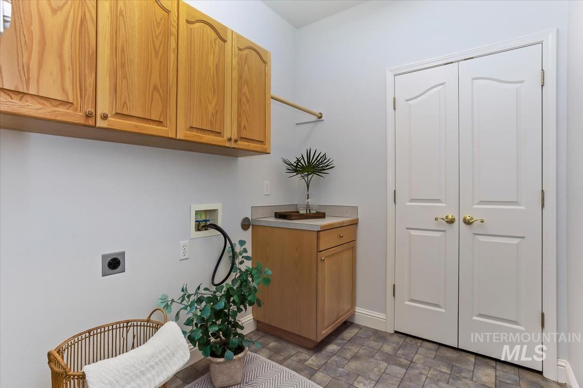 25074 The Driving Lane Caldwell, ID 83607 - Photo 21 of 29 Laundry room with stone finish floors, washer hookup, cabinet space, and electric dryer hookup