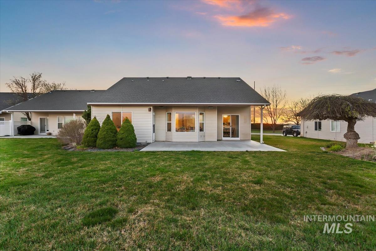25074 The Driving Lane Caldwell, ID 83607 - Photo 28 of 29 Rear view of property featuring a patio, a yard, and a shingled roof