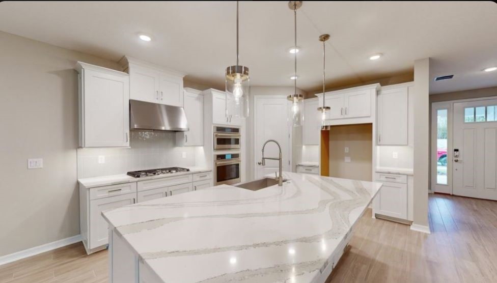 86579 Oar Row North Yulee, FL 32097 - Photo 7 of 28 a kitchen with stainless steel appliances kitchen island granite countertop a refrigerator a stove oven a sink with island and chairs