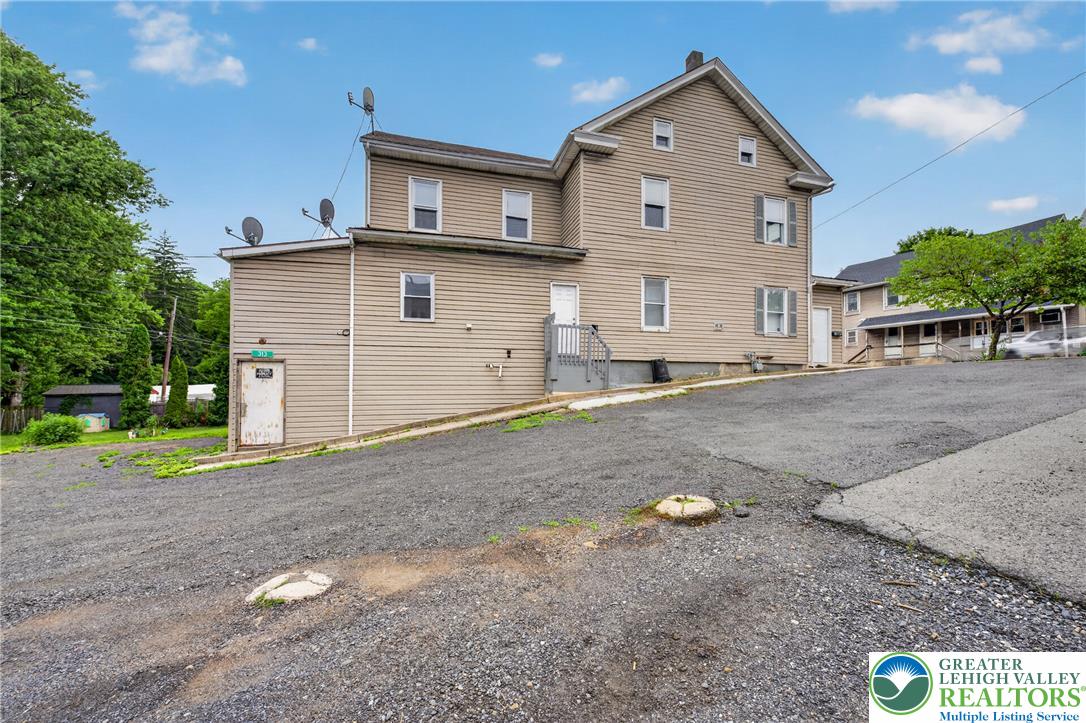 313 Main Street Slatington, PA 18080 - Photo 66 of 73 A classic two-story structure with tan siding, showcasing multiple windows and a practical exterior staircase.