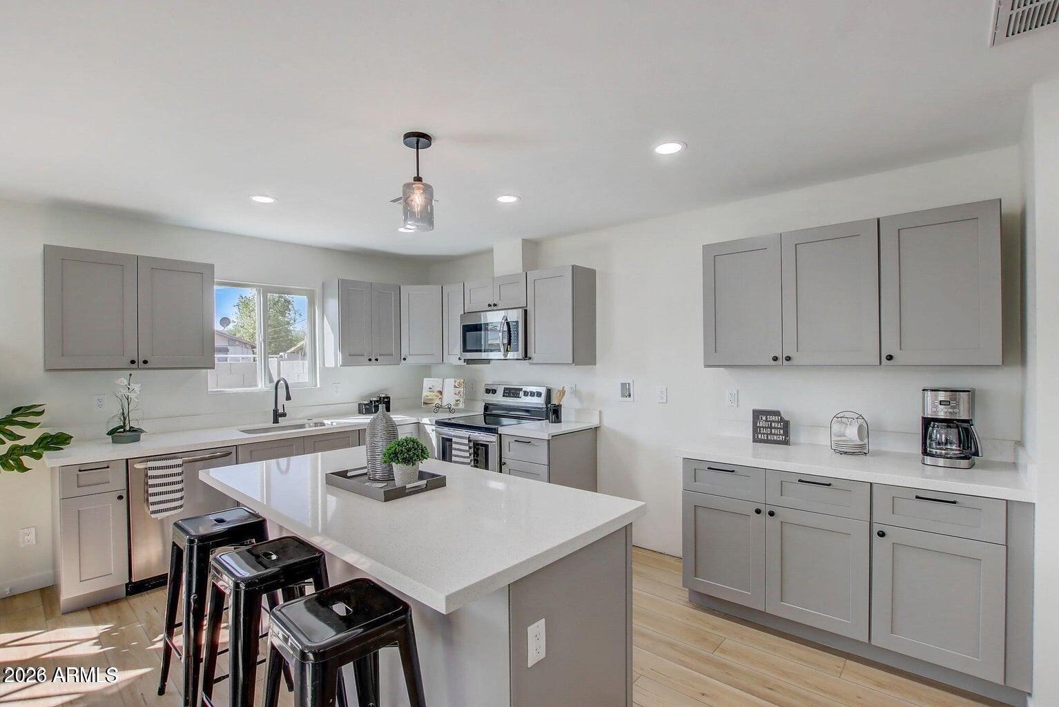 2509 East Broadway Road, Unit 2 Phoenix, AZ 85040 - Photo 25 of 47 a kitchen with a sink stove cabinets and chairs