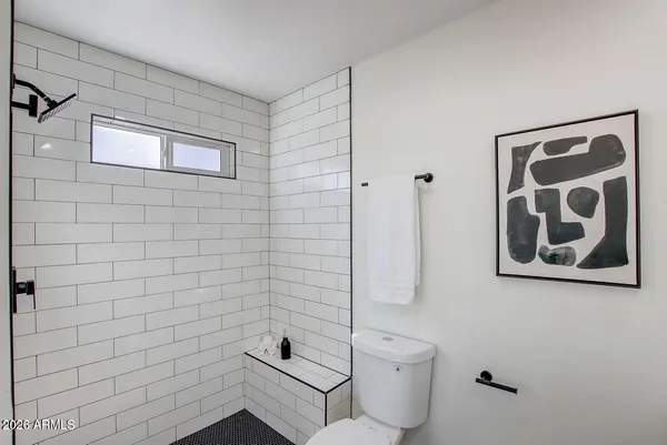 a view of a hallway with wooden floor and a bathroom