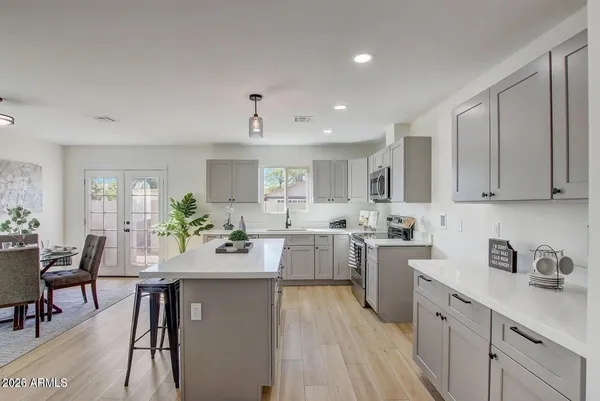 a kitchen with a sink stove cabinets and wooden floor