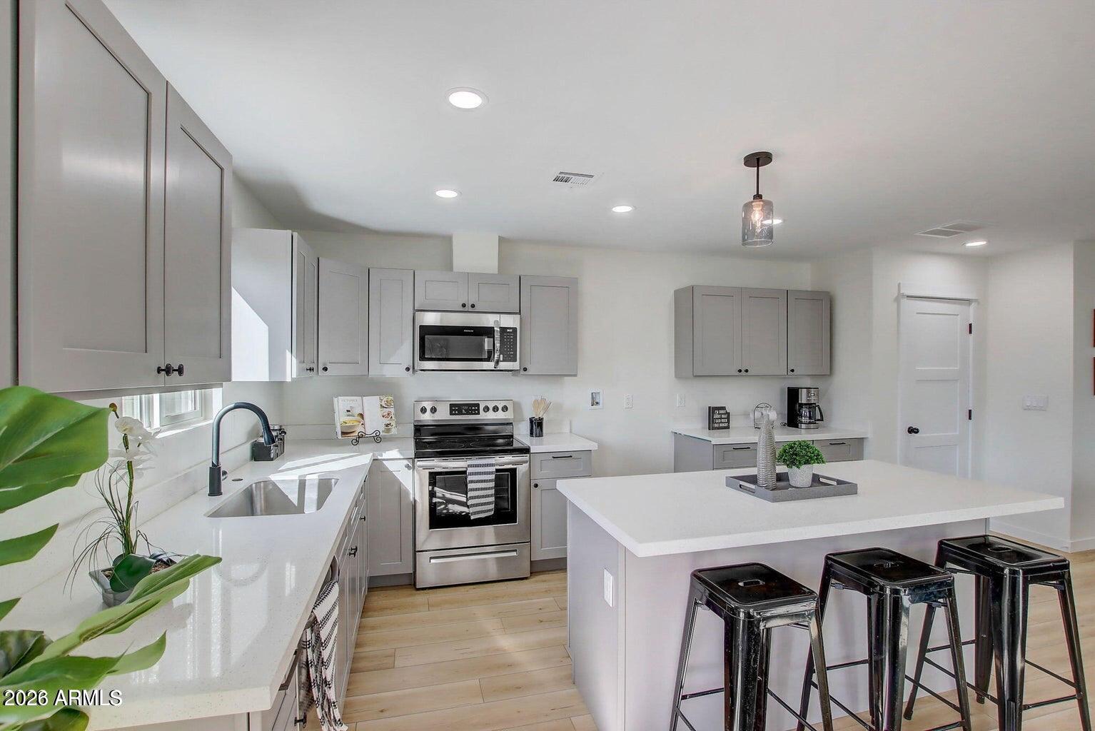 2509 East Broadway Road, Unit 2 Phoenix, AZ 85040 - Photo 5 of 47 a kitchen with stainless steel appliances granite countertop a sink a stove a refrigerator cabinets and chairs