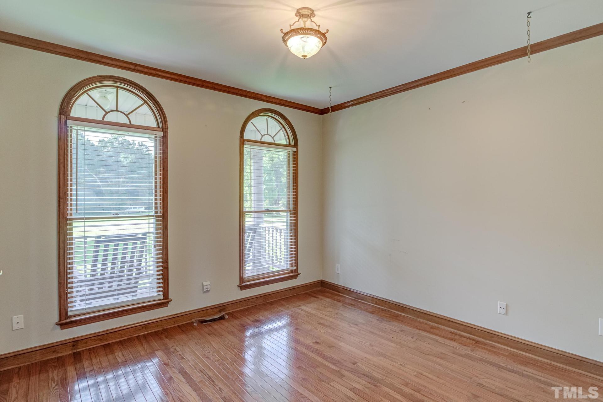 2213 East Garner Road Raleigh, NC 27610 - Photo 16 of 74 an empty room with wooden floor fan and windows