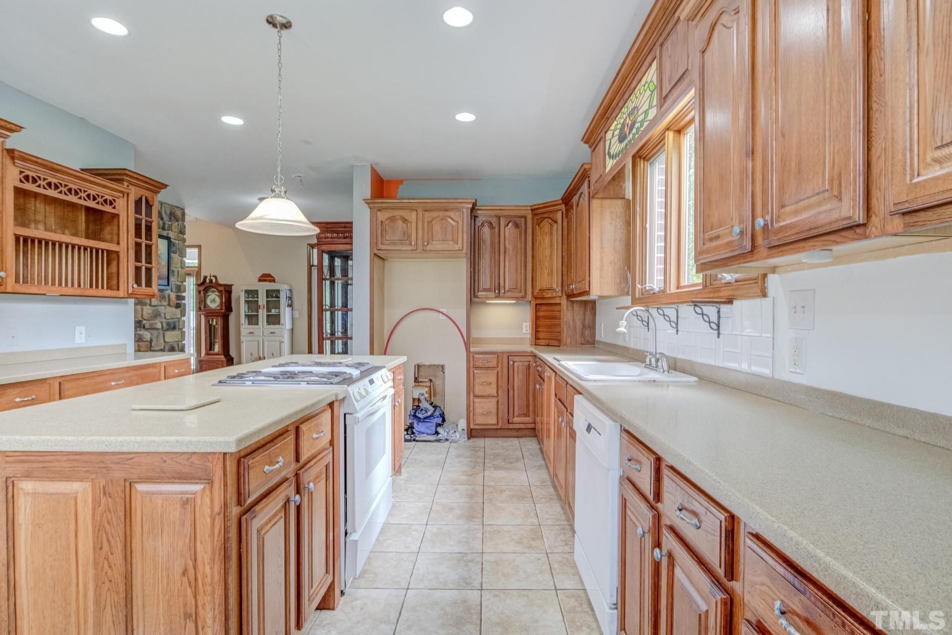 2213 East Garner Road Raleigh, NC 27610 - Photo 30 of 74 a kitchen with stainless steel appliances granite countertop a sink and cabinets