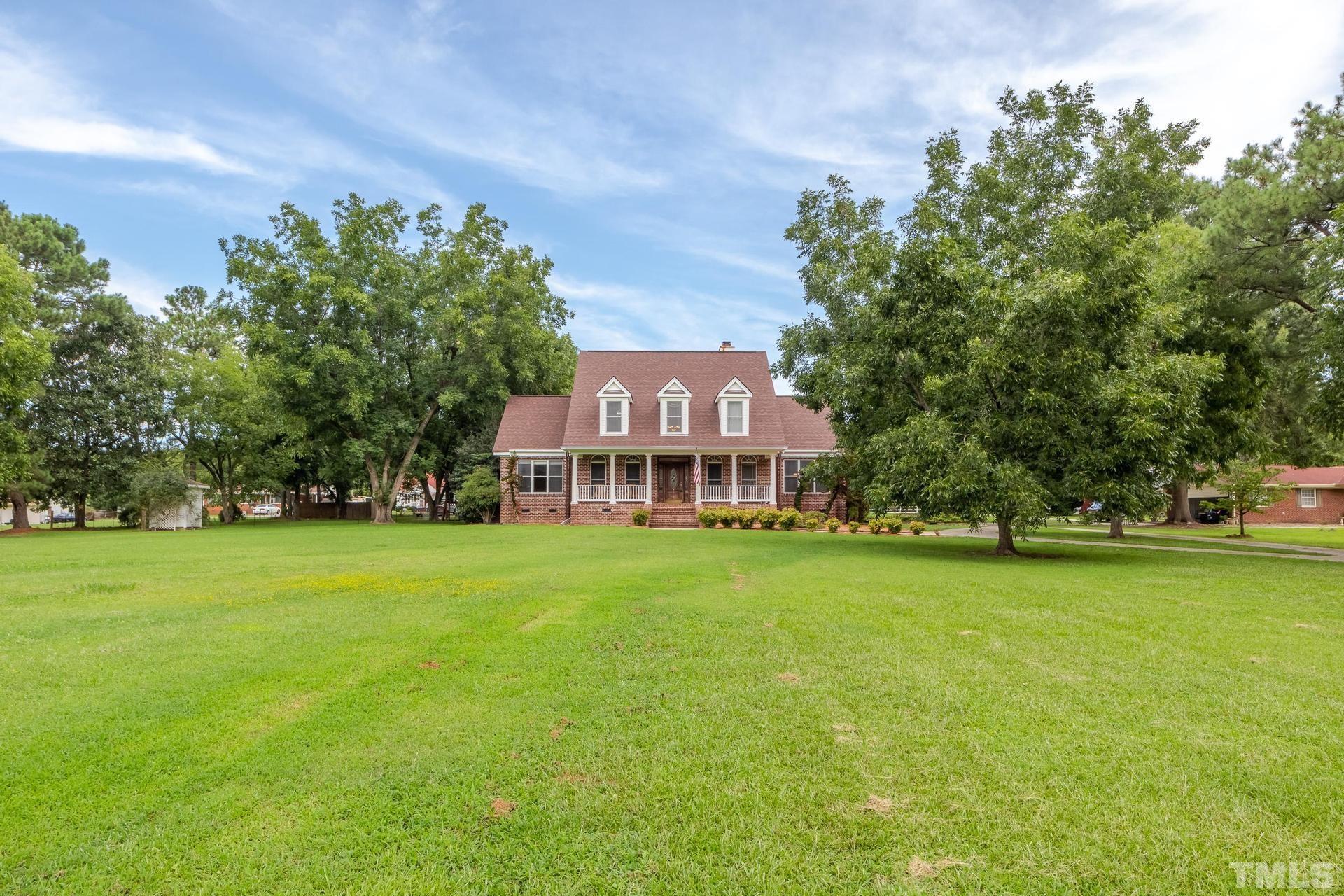 2213 East Garner Road Raleigh, NC 27610 - Photo 3 of 74 a view of a big house with a big yard and large trees