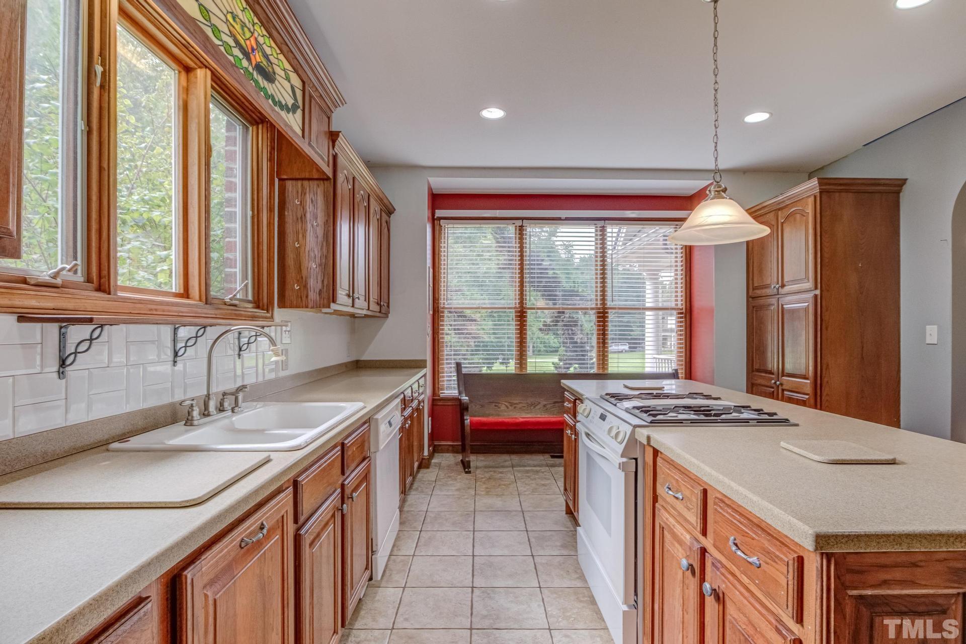 2213 East Garner Road Raleigh, NC 27610 - Photo 31 of 74 a kitchen with stainless steel appliances granite countertop a sink stove and cabinets