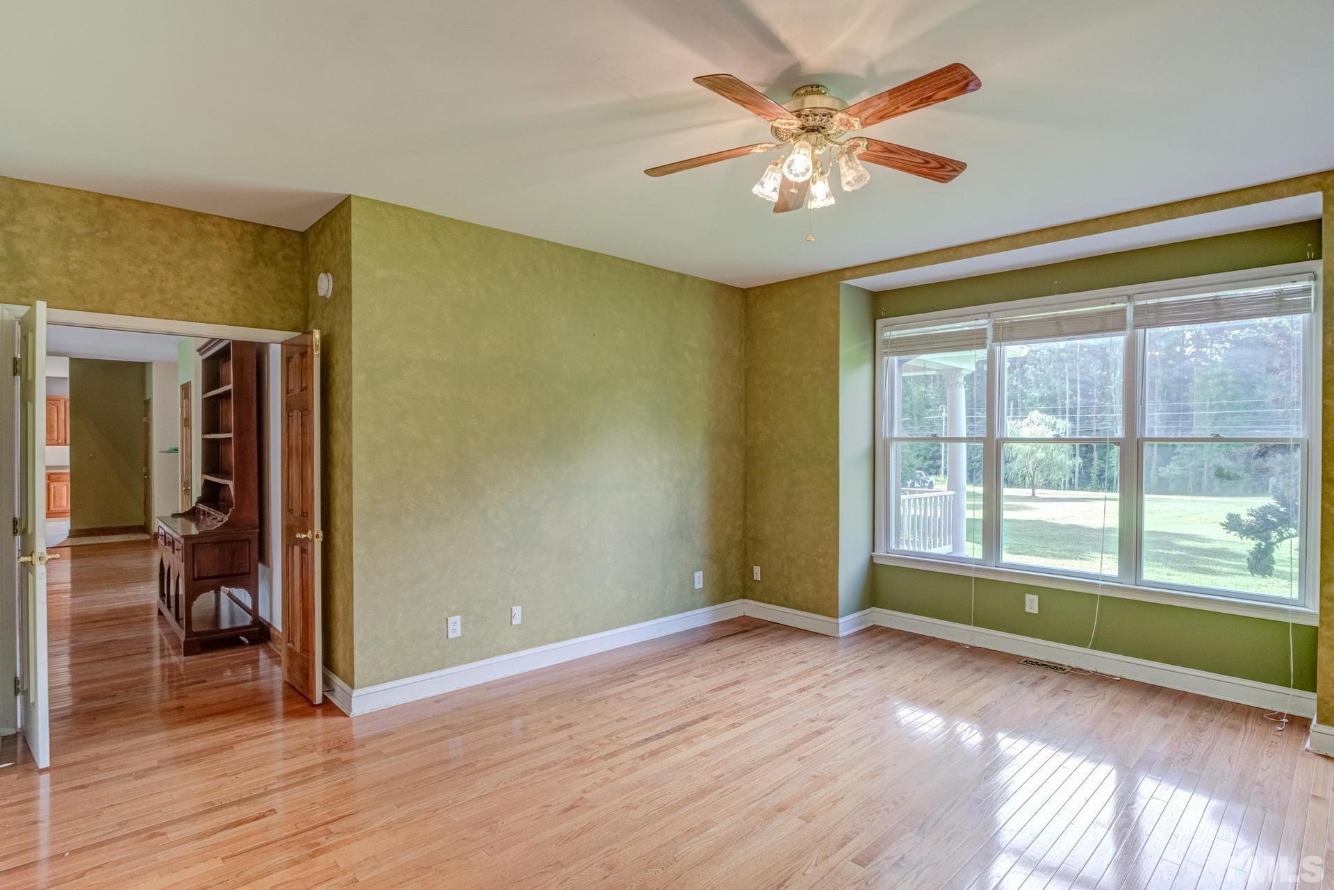 2213 East Garner Road Raleigh, NC 27610 - Photo 37 of 74 an empty room with wooden floor and a ceiling fan