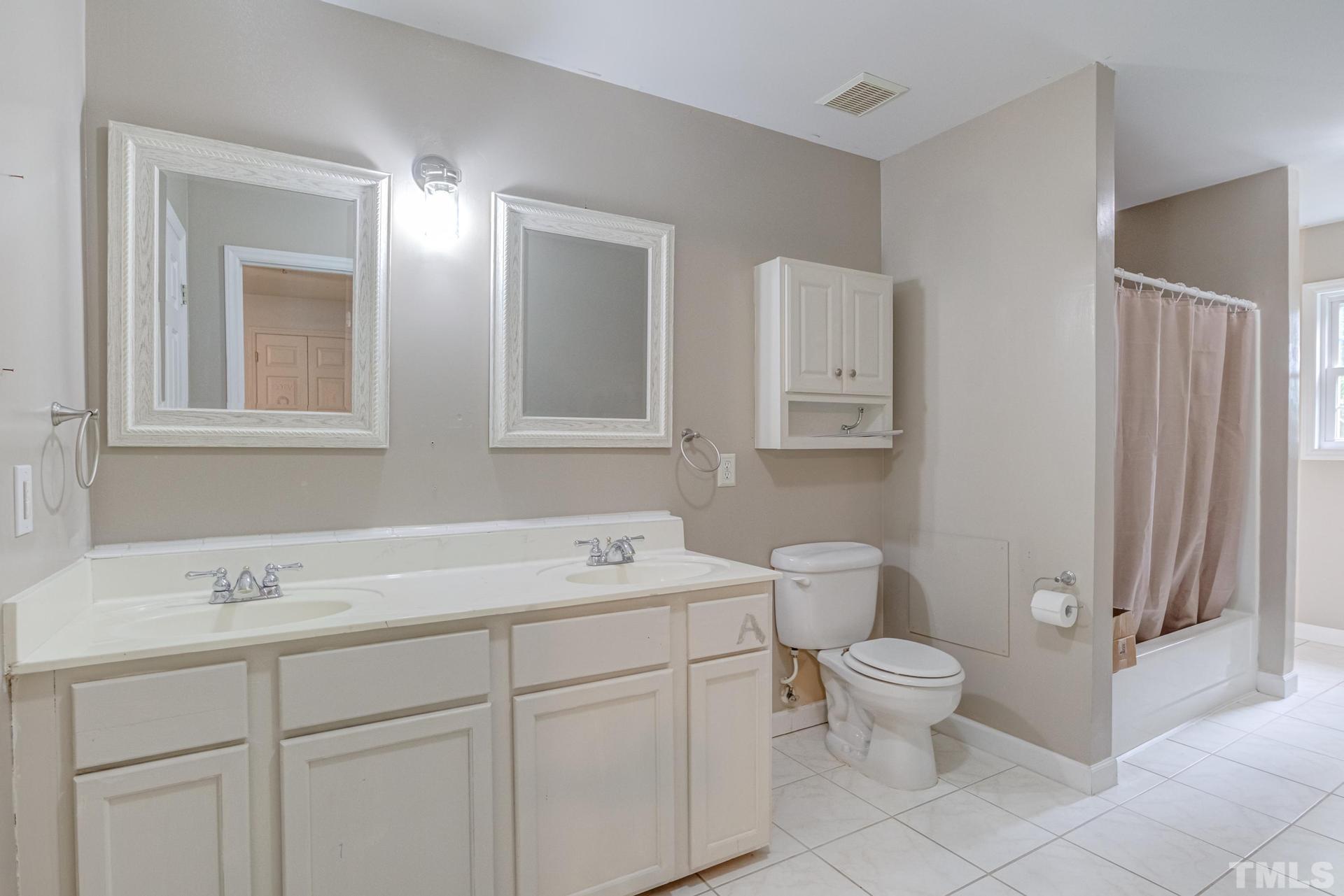 2213 East Garner Road Raleigh, NC 27610 - Photo 46 of 74 a bathroom with a toilet sink and mirror