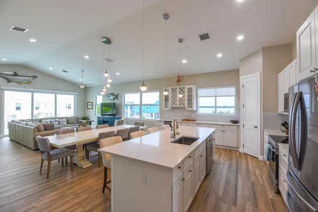 a kitchen with stainless steel appliances a dining table chairs microwave and cabinets