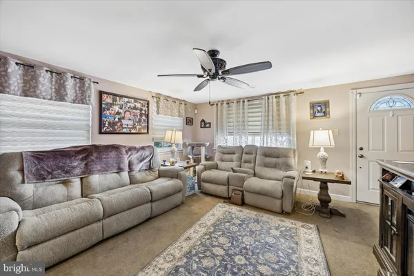 a living room with furniture ceiling fan and a rug