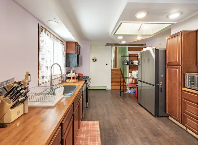a kitchen with stainless steel appliances granite countertop a refrigerator stove and sink