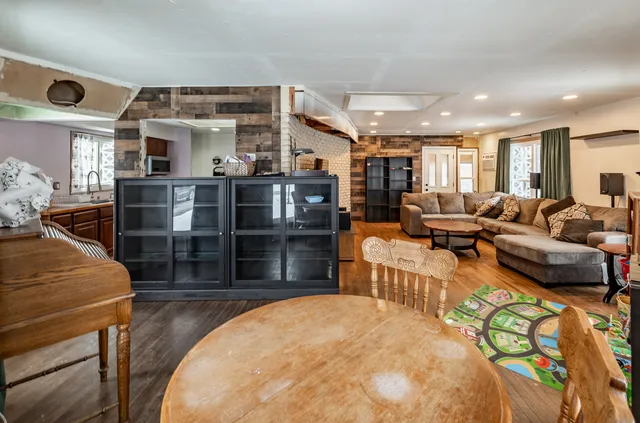 a living room with furniture a flat screen tv and a large window